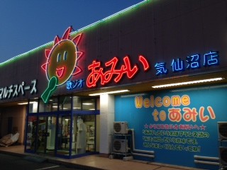 夜に光る太陽の看板とあみいの外観